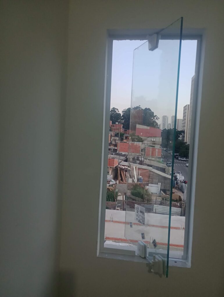 Janela vertical pivotante, com vidro de 8mm transparente. Instalado em Itapevi pela Lcarlos Vidraçaria.